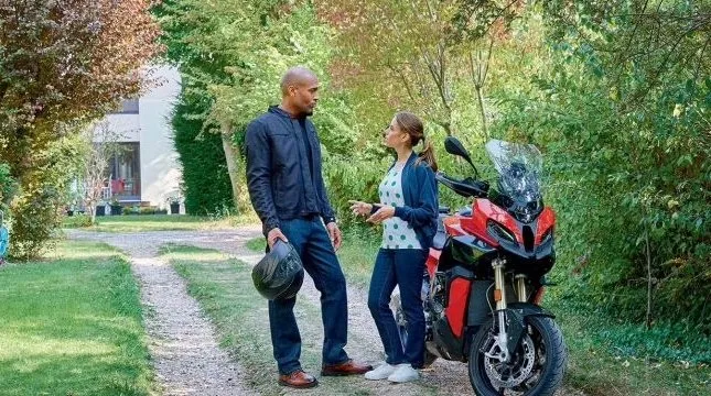 Deux personnes discutant près d'une moto